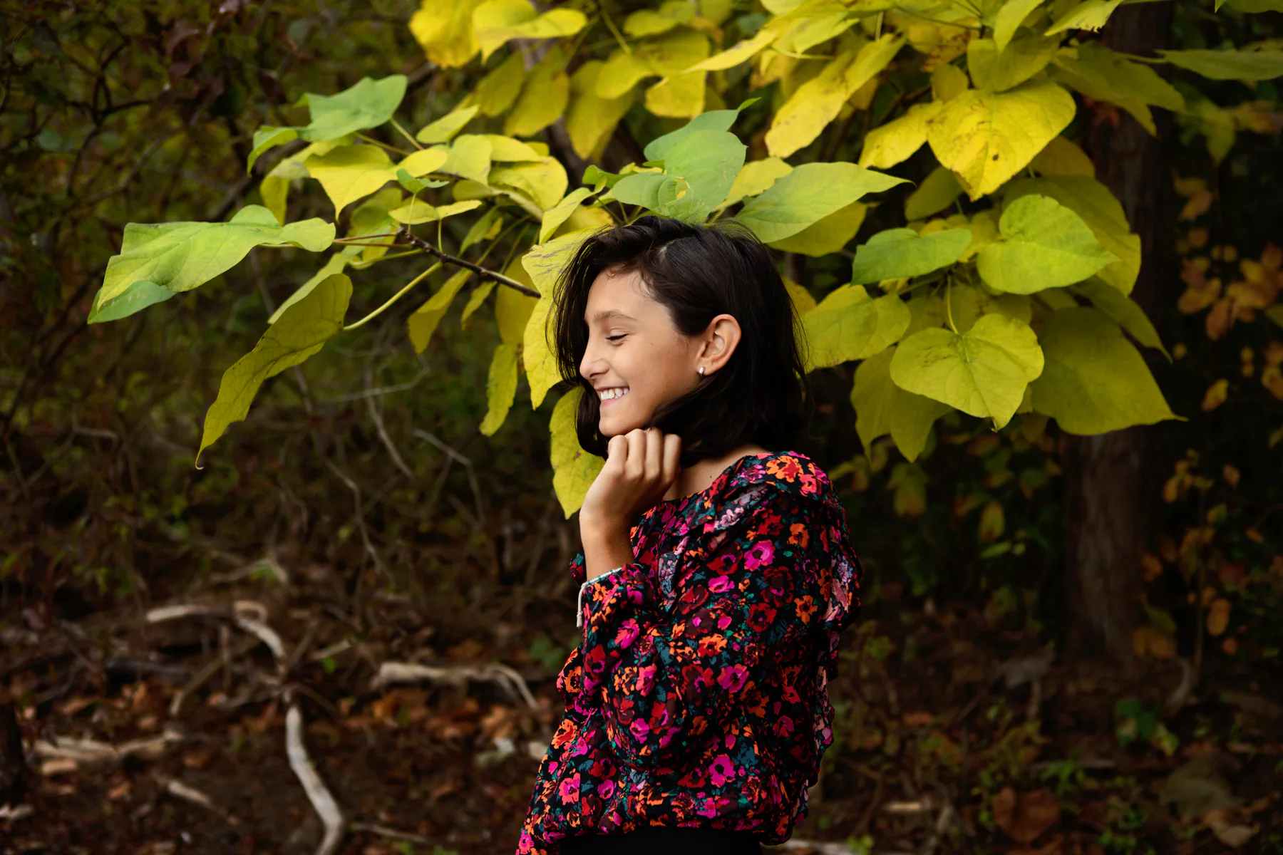 Girl smiling among autumn leaves during a Baltimore family photography session