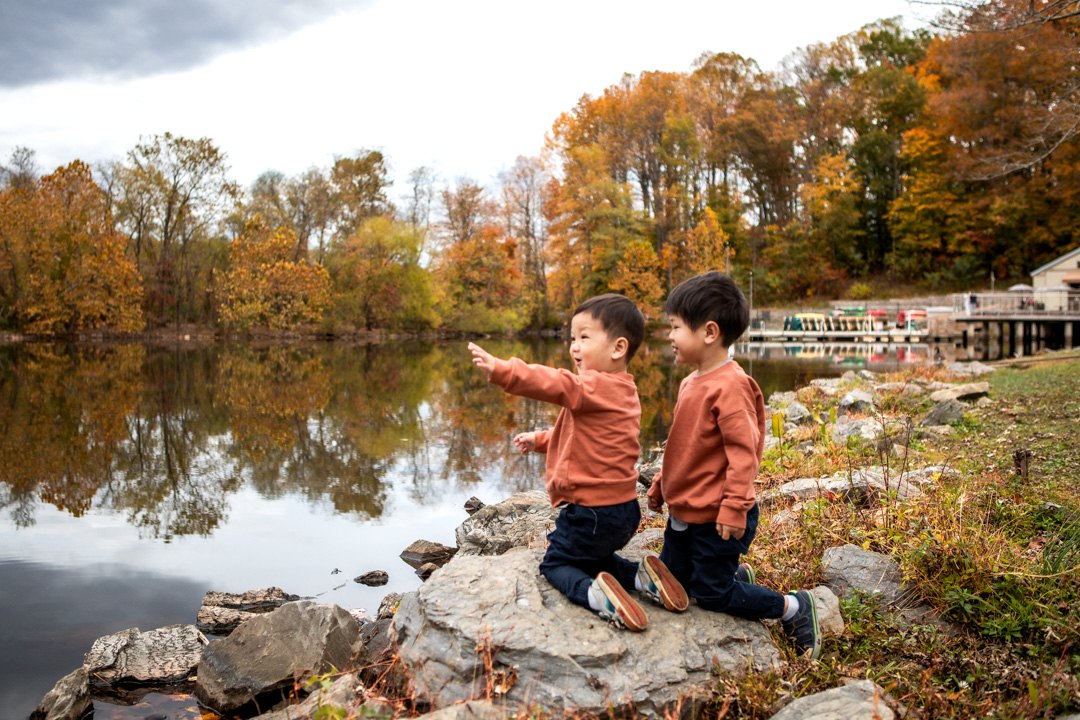 Two brothers exploring beside a lake during an autumn family photography session