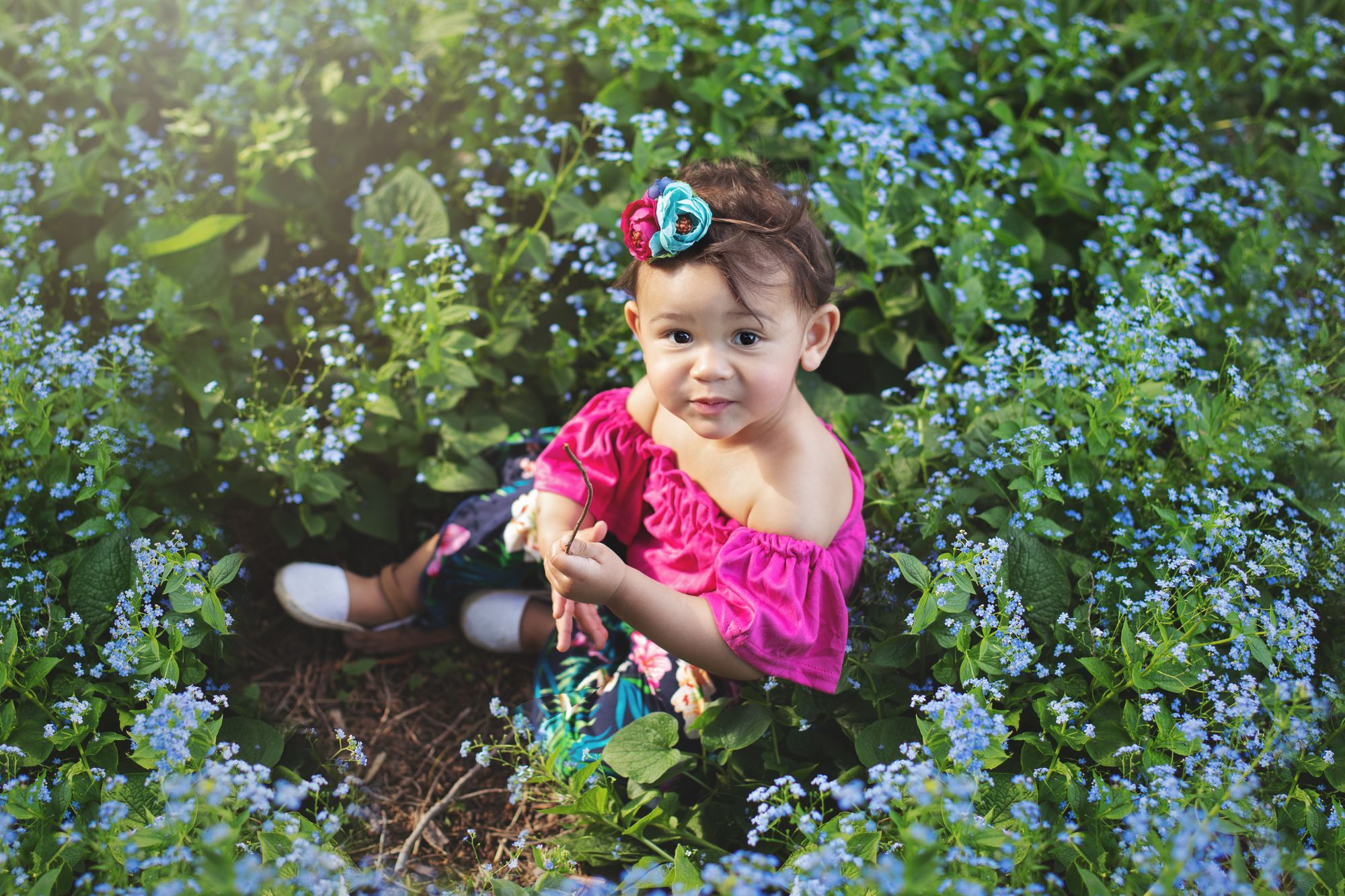 Toddler sitting in flowers in outdoor session