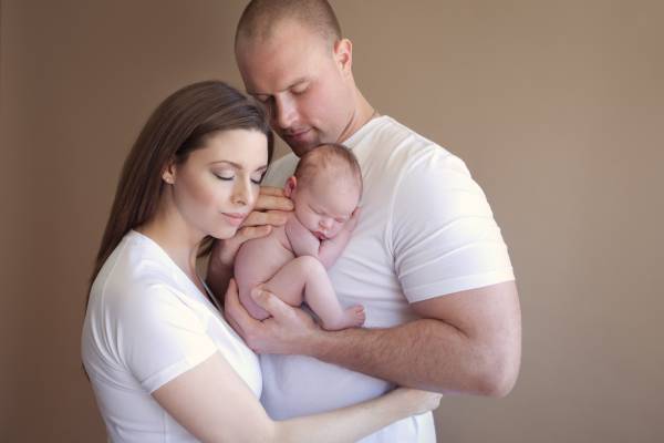 Pikesville parents holding their newborn during studio portrait session
