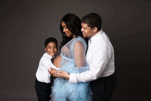 partner and older child in coordinated neutral tones for maternity session