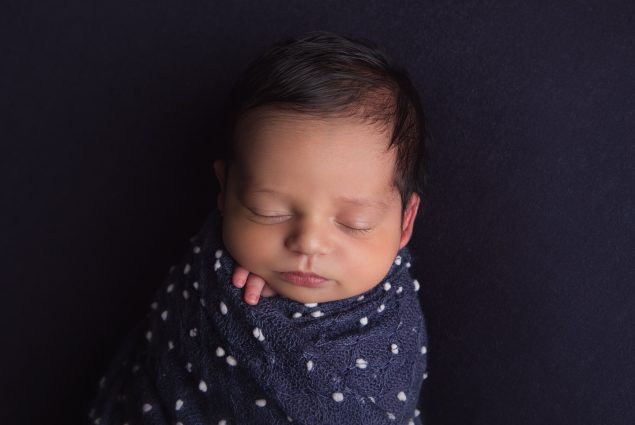 Baby boy wrapped in blue in a professional studio photoshoot