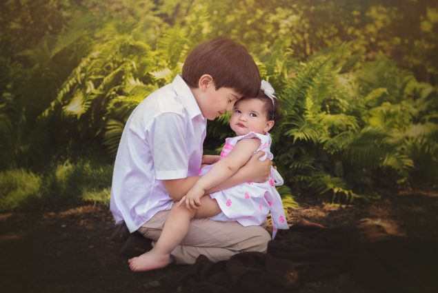 One year old toddler posing with brother