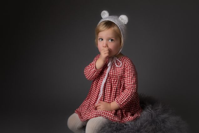 Studio portrait of a toddler girl sucking her thumb