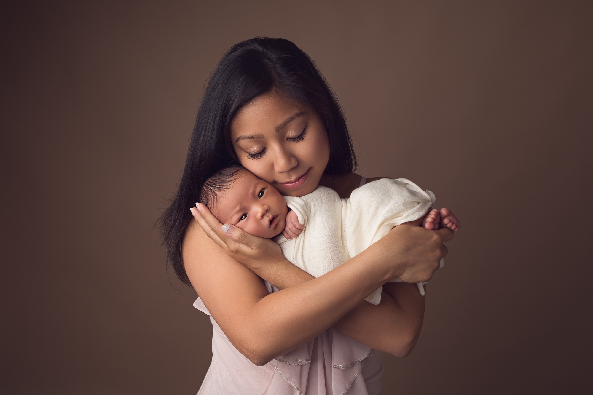 mom holding her newborn during a photoshoot in studio