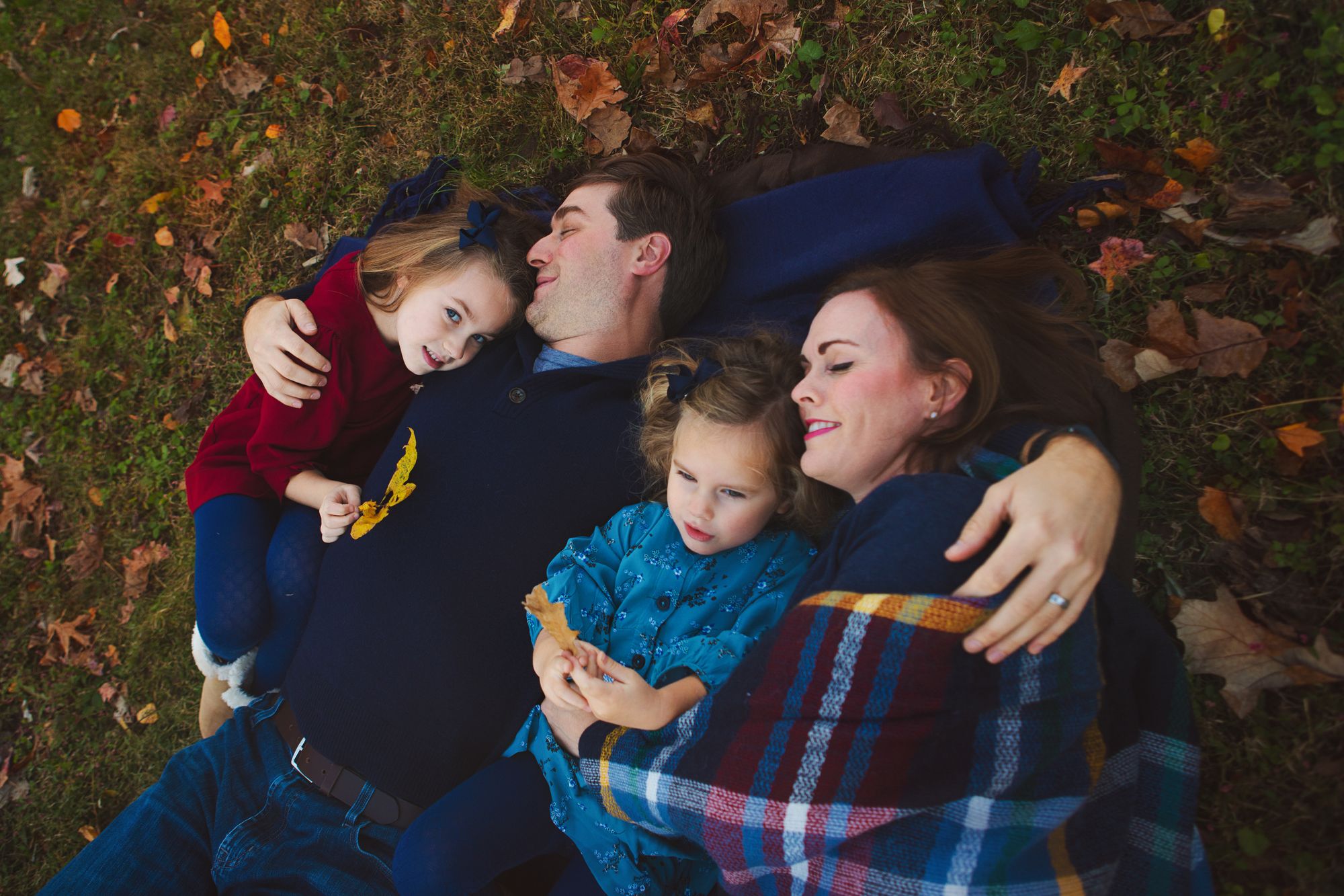 Family posing on grass during an outdoor photo shoot