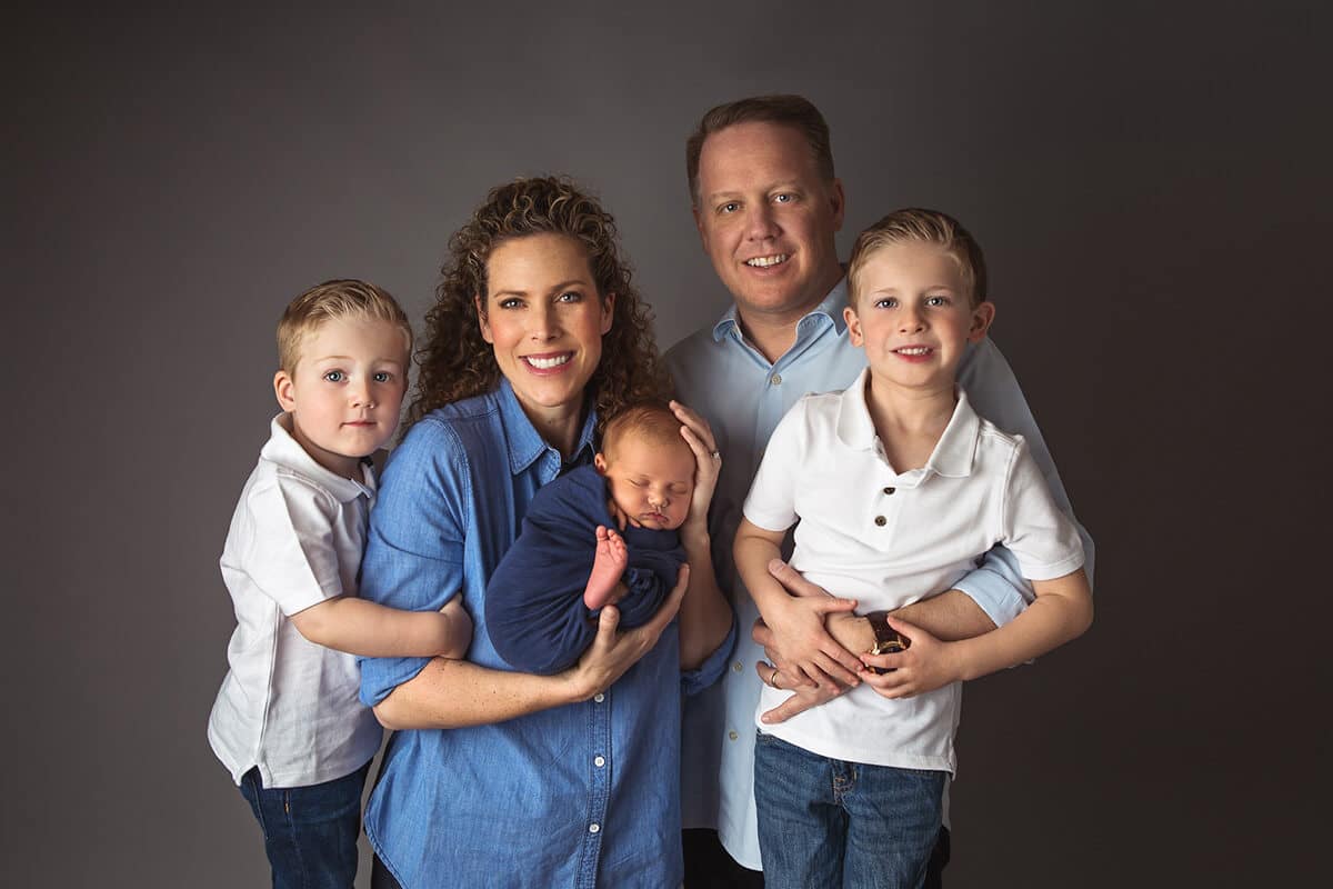 Portrait of family in blue clothes - parents, siblings, newborn