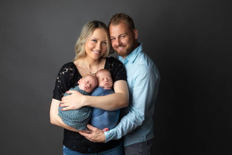 Newborn twin photoshoot Baltimore MD - mom and dad holding twins in studio