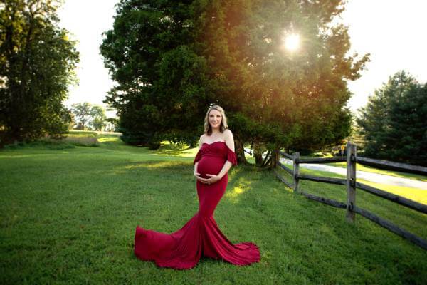 pregnant woman in a burgundy gown at an outdoor Maryland maternity session in fall