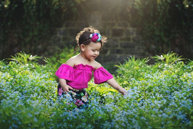 Baby girl in blue flower field