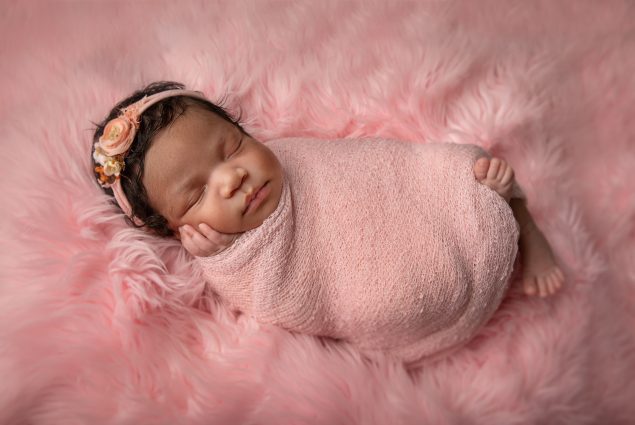Baby girl swaddled in pink
