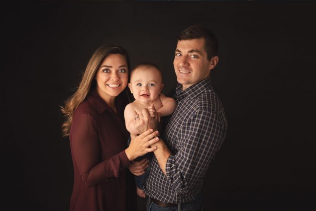 Mom and dad holding their baby in Baltimore studio photoshoot