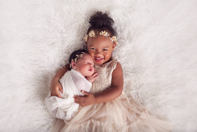 Baby and newborn hugging in studio session in Baltimore