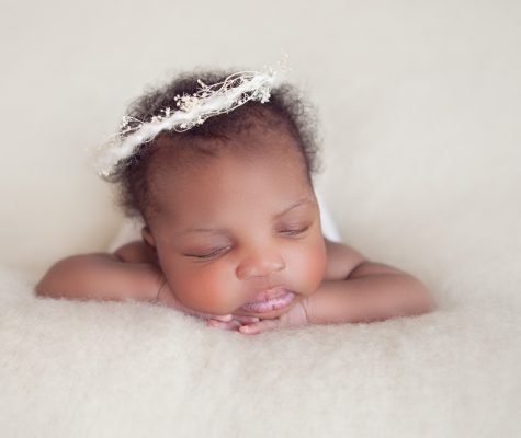 Baby girl with a wreath on white background