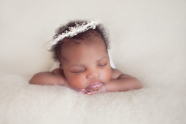 Baby girl with a wreath on white background