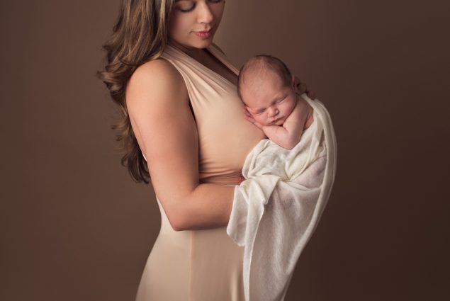 Mom and newborn posing in studio photoshoot