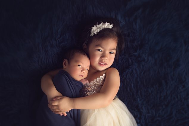 Newborn and toddler portrait on a blue blanket