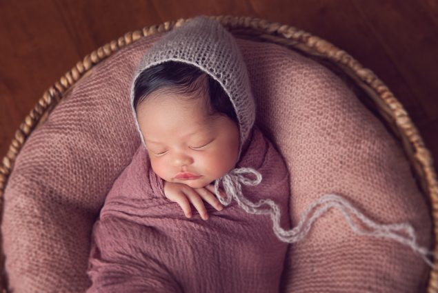 Newborn sleeping in wicker basket