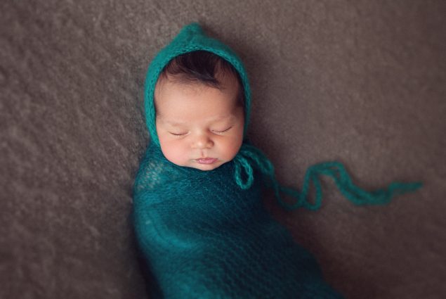 Picture of newborn swaddled in green