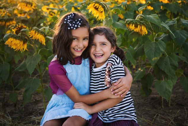 Portrait of two girls in a sunflower field