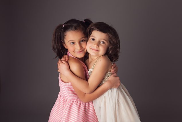 Sisters hugging in studio portrait