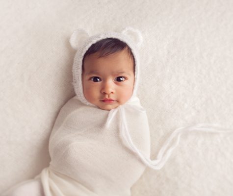 Swaddled newborn on white background